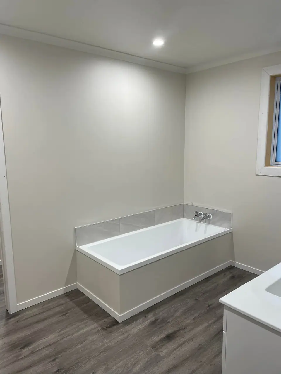Renovated bathroom with built-in bath, vanity and downlights