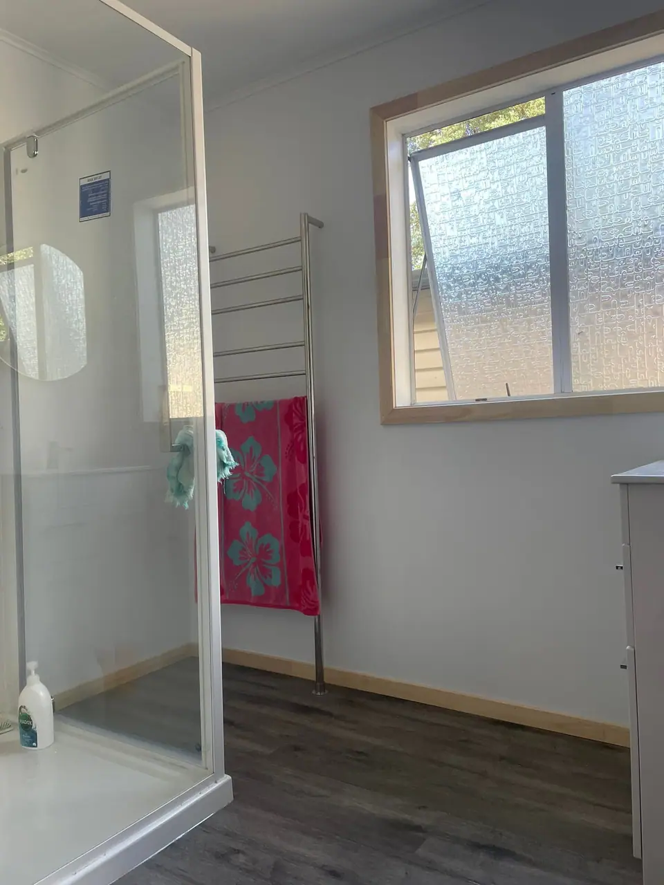 Completed bathroom renovation with shower enclosure and towel rail