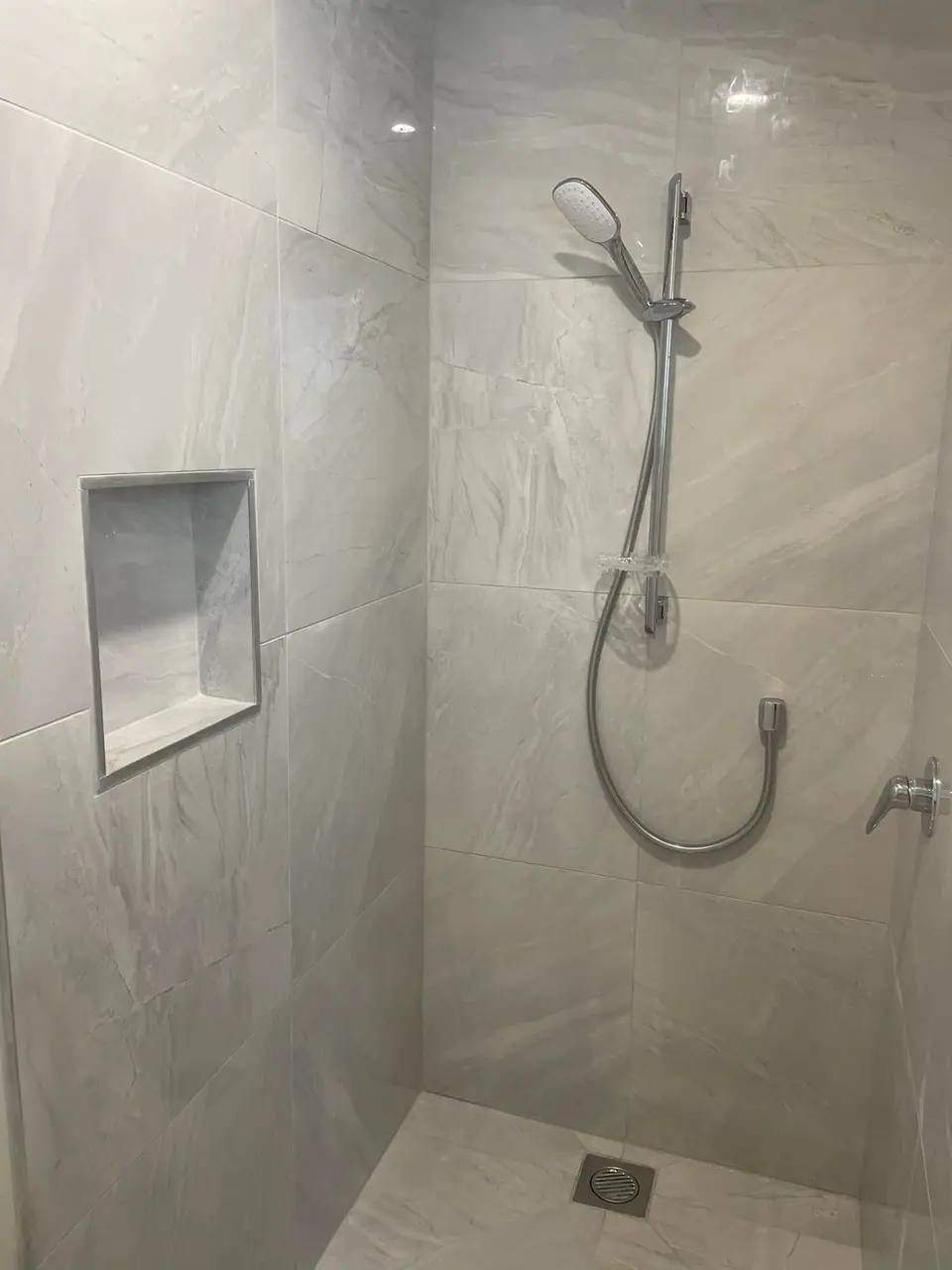 Tiled walk-in shower with recessed niche in a renovated bathroom in Taranaki