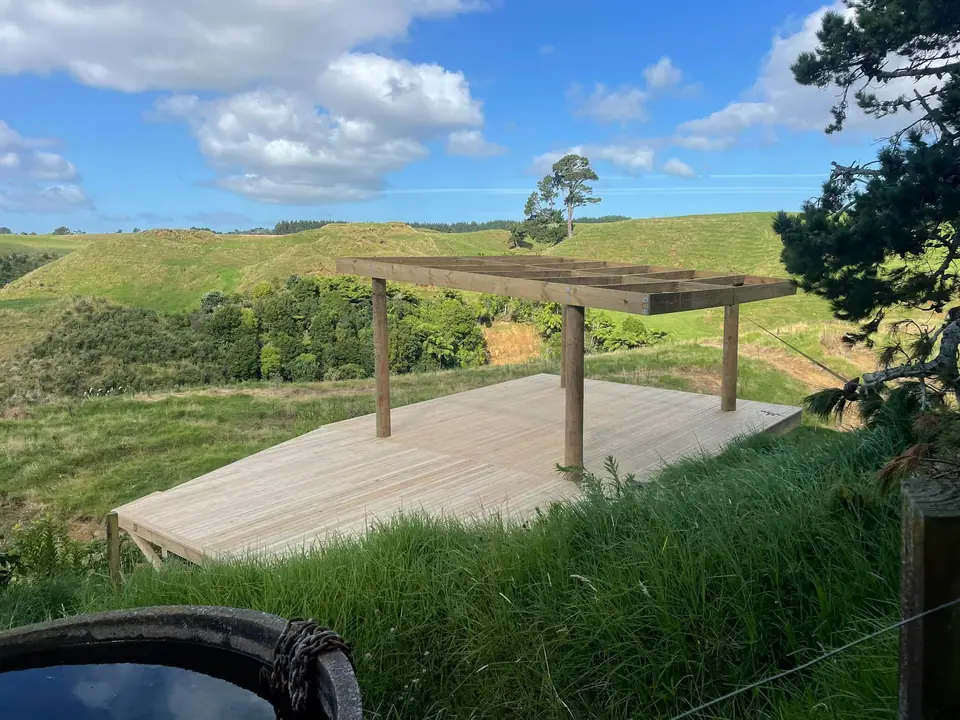 New deck and pergola framing on a hillside section