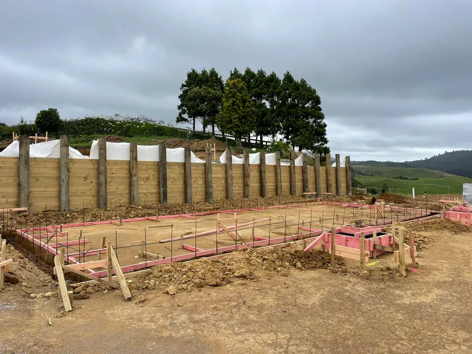 Foundation boxing and timber pole retaining wall on a building site