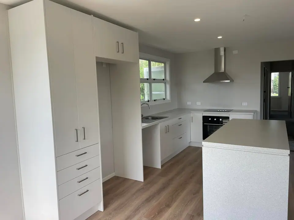 White kitchen joinery with tall pantry, wall oven and island