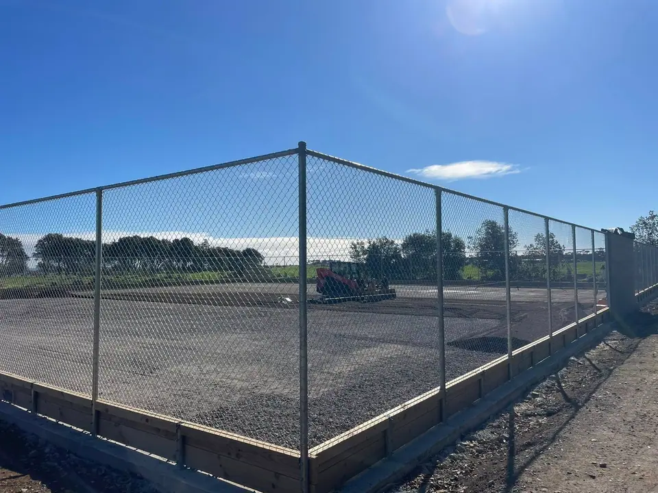 Concrete yard with chain-link fencing on a rural site