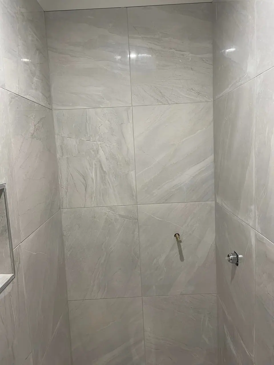 Large format wall tiles in a newly tiled shower