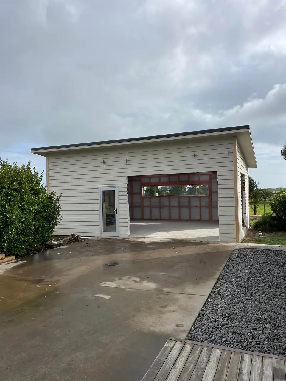 Small standalone building with garage door and concrete apron