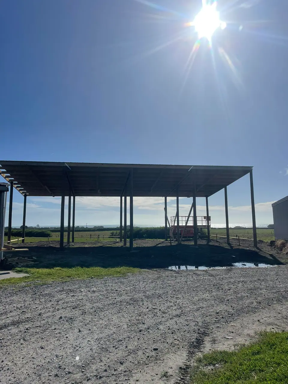 Steel roof structure over a new concrete pad